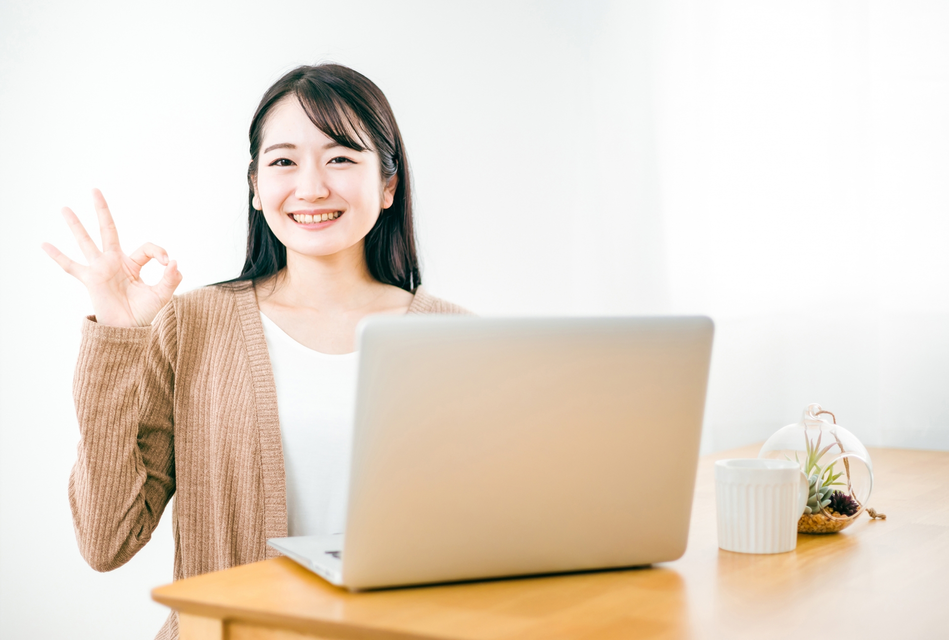 女性がパソコン前で〇をしている写真